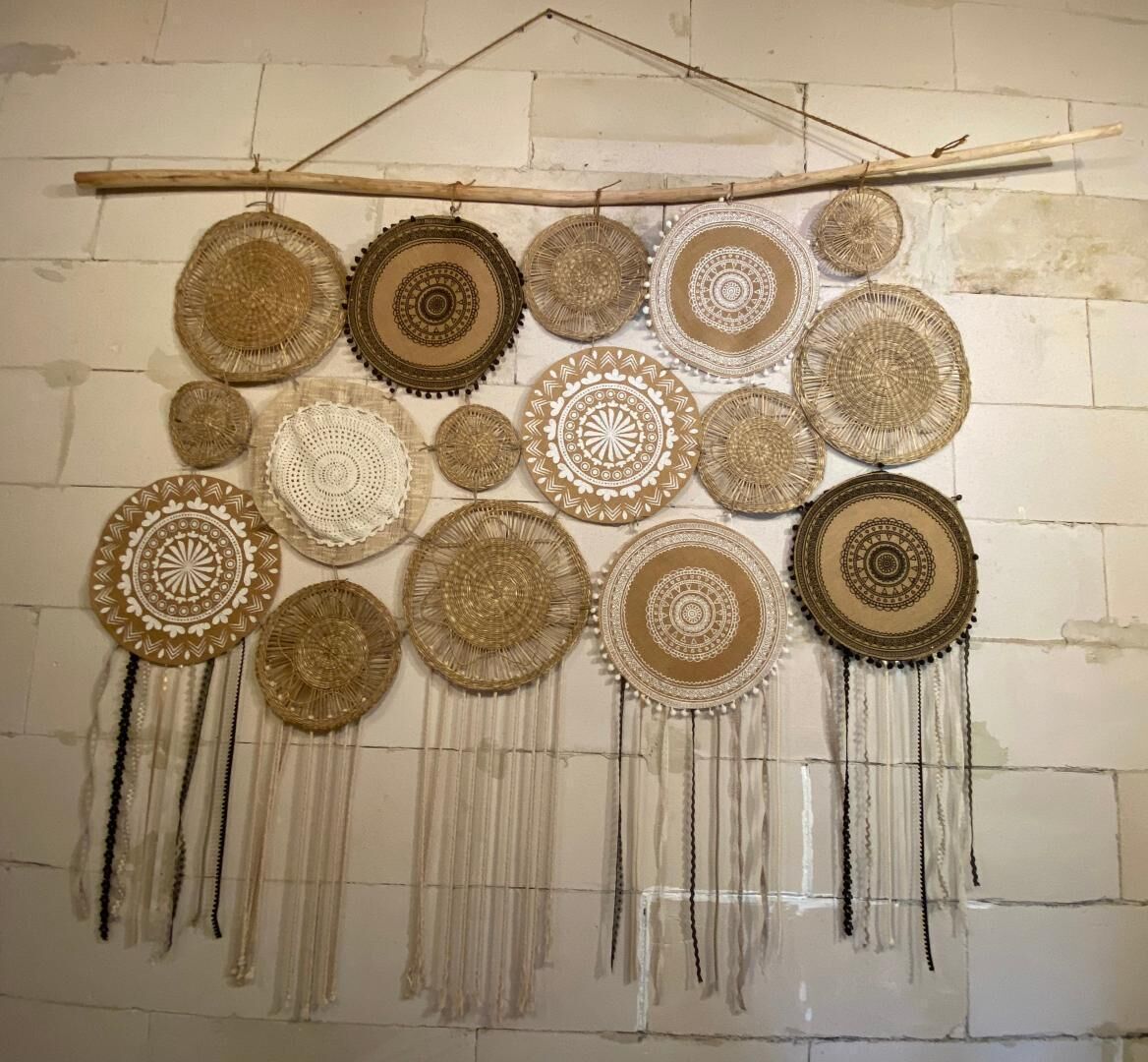 A wall with a series of circular woven patterns and fringes.