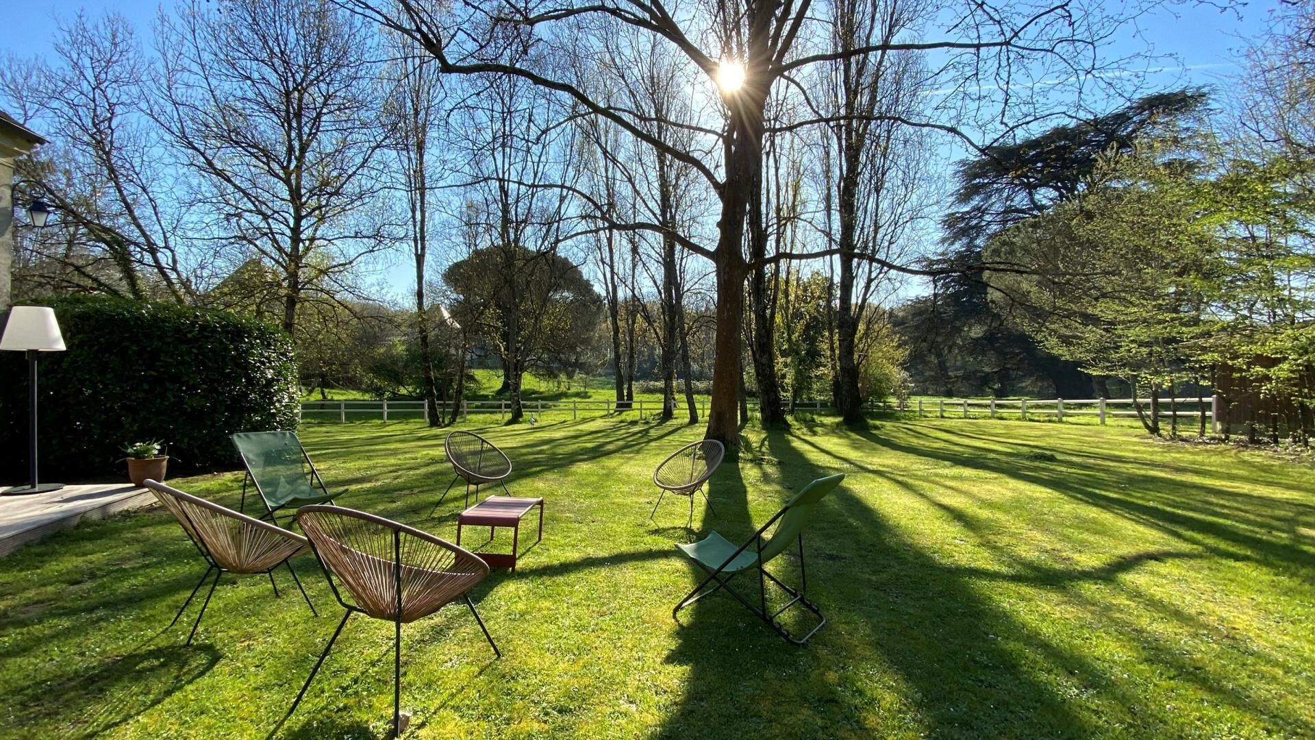 A grassy outdoor area with chairs and a lamp post.