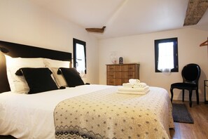 A bedroom with a bed, a dresser, a chair, and a window.