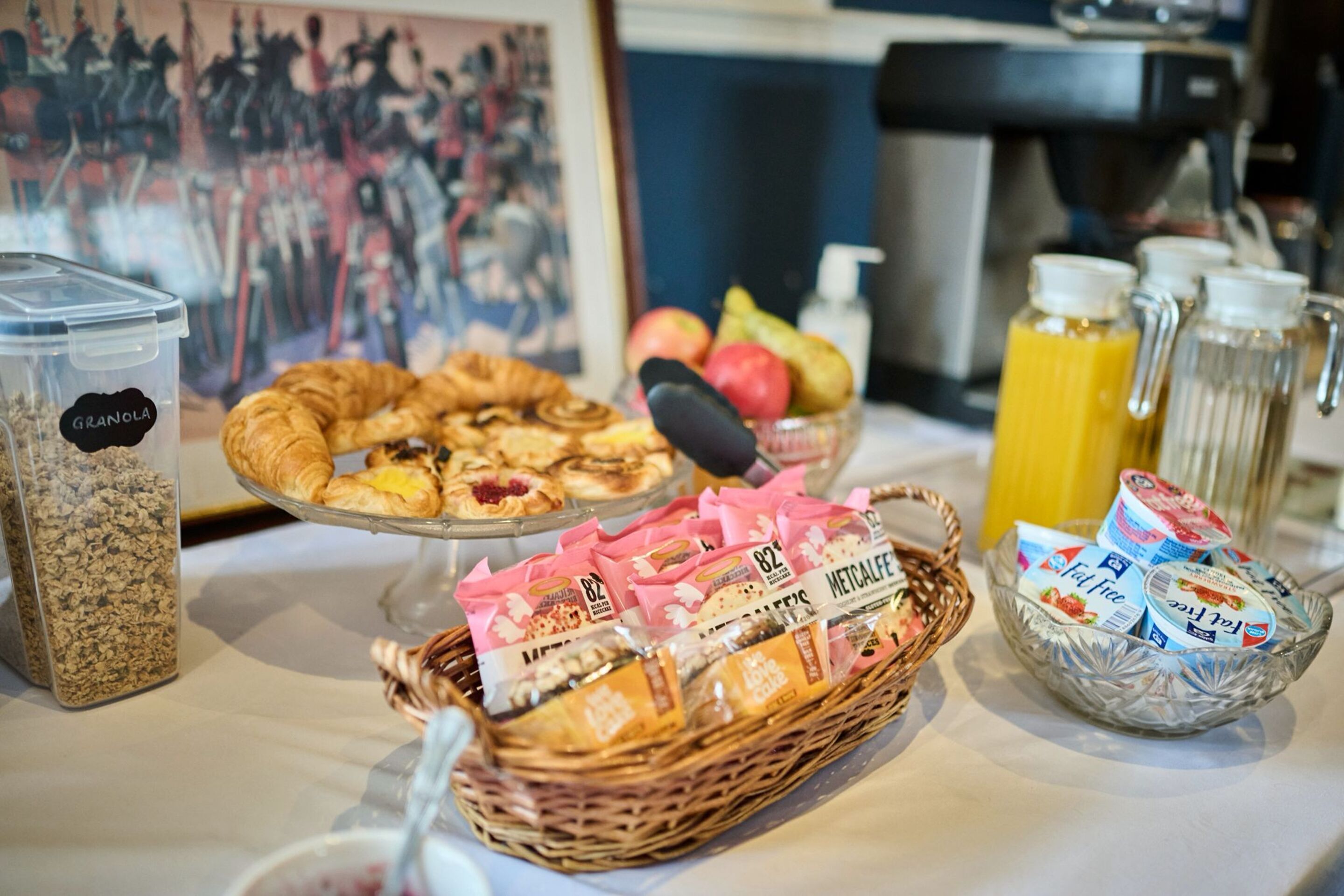 Ein Frühstücksbuffet mit verschiedenen Speisen, darunter Backwaren, Früchte und verpackten Produkten.