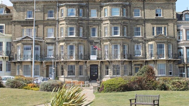 A multi-story building with a symmetrical facade, large windows, and a central entrance. - Lord Kitcheners Guest House (Lowestoft)