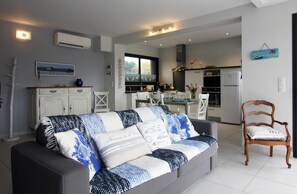Relax in this stylish living space with a sofa, dining area, and fully equipped kitchen.