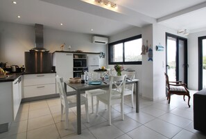 Enjoy meals in the kitchen with stainless steel appliances and a dining area with a wooden table.
