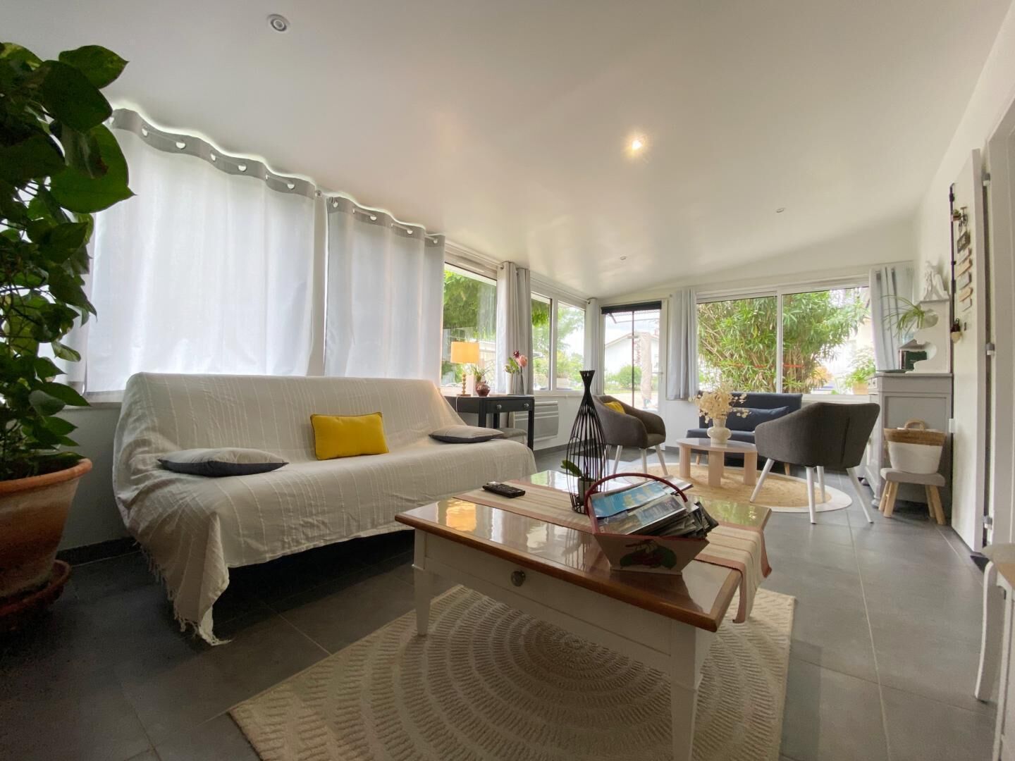 A modern living room with a sofa, coffee table, and a dining area with chairs.