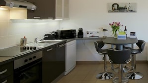 Eine moderne Küche mit Essbereich, einschließlich Herd, Backofen, Mikrowelle und Tisch mit Stühlen.