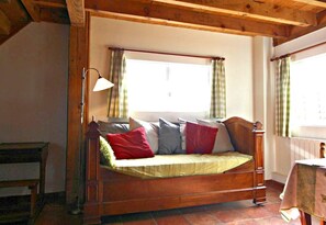 A wooden bed with a headboard, a bedside lamp, and a window with curtains.
