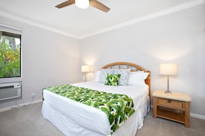 Quarto com cama, duas luminárias de cabeceira, mesa de cabeceira de madeira e janela com vista para área verde.