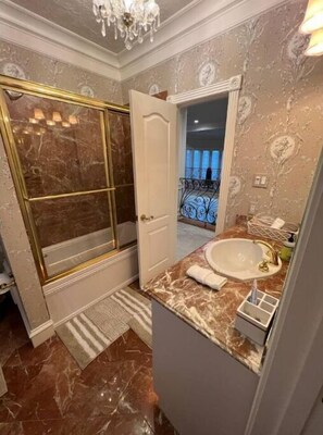 Bathroom features a large mirror, shower, and floral-patterned walls.