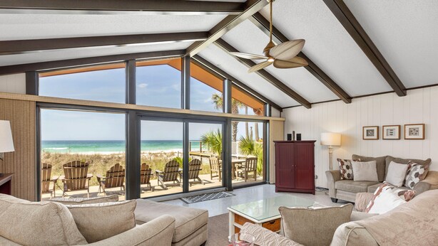 A spacious living room with a large glass door leading to a balcony overlooking a beach. - Gulf Front 3bd/2ba Home With Private Beach Access! (Panama City Beach)
