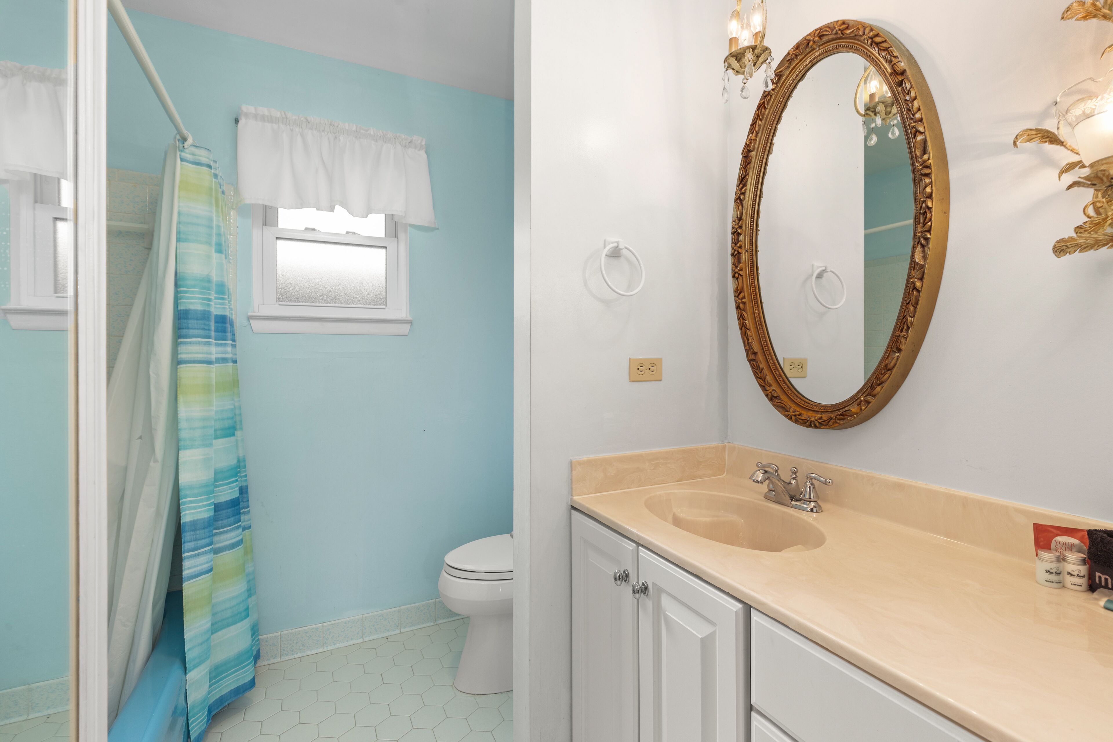 A bathroom with a white sink, a mirror, and a toilet.
