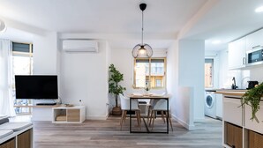 En modern lägenhet med matplats, kök och vardagsrum.