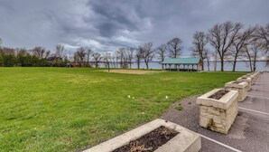 A park with a grassy area, a stone planter, and a gazebo by a body of water. - Cozy Solar-Powered Loft: Walk to Lake Champlain! (St. Albans Town)