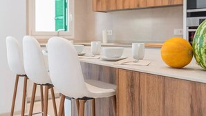 A modern kitchen with wooden cabinets, a white countertop, and a window with green shutters. - House in Sineu with excellent views of the Tramuntana (Sineu)