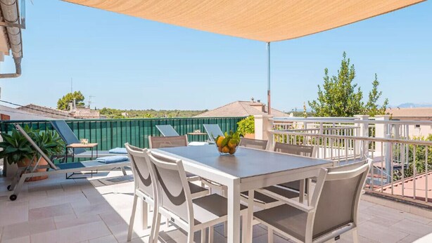 An outdoor patio with a table and chairs, a large shade sail, and a view of the surrounding area. - House in Sineu with excellent views of the Tramuntana (Sineu)