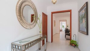 A hallway with a decorative mirror, a console table, a potted plant, and a framed picture on the wall. - House in Sineu with excellent views of the Tramuntana (Sineu)