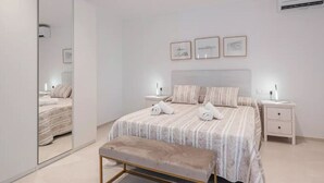 A modern bedroom with a large bed, bedside tables, a bench, and framed pictures on the wall. - House in Sineu with excellent views of the Tramuntana (Sineu)