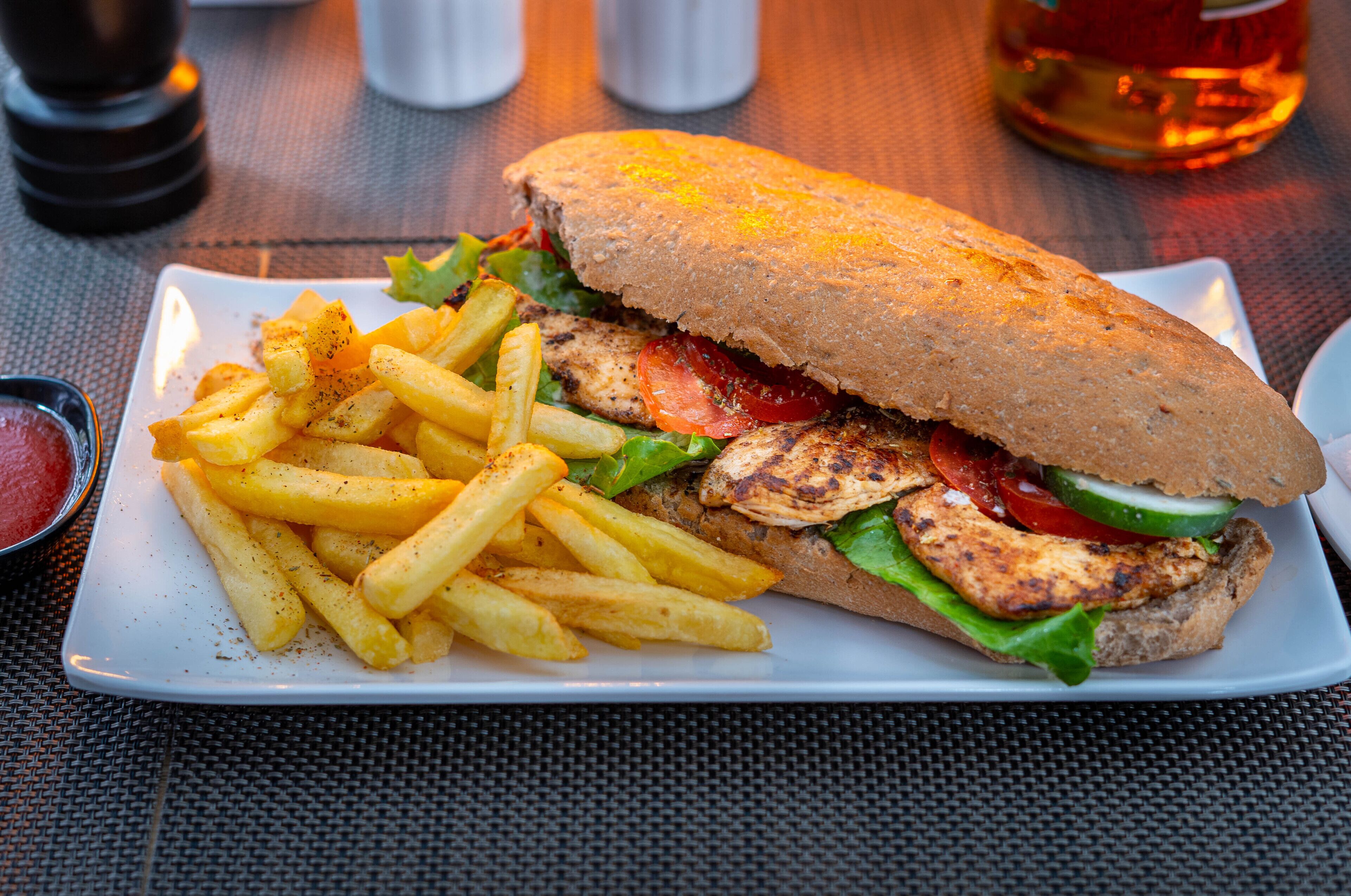 Un sándwich con papas fritas en un plato blanco.