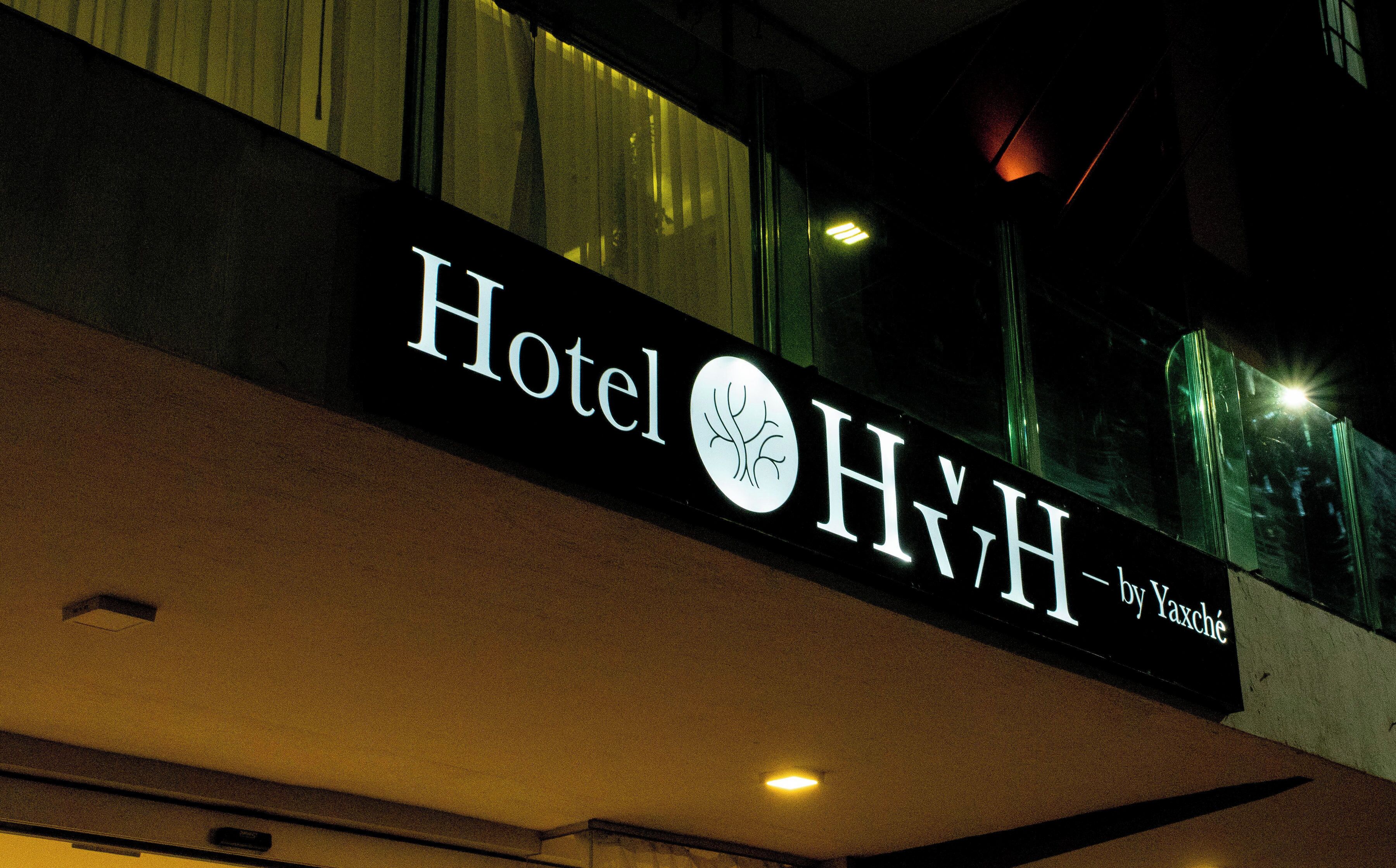 A hotel sign with the name "Hotel HYH" and the name "Yaxché" below it.