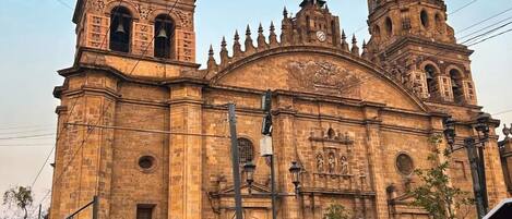 Uma igreja histórica com duas torres imponentes e uma carruagem na frente.