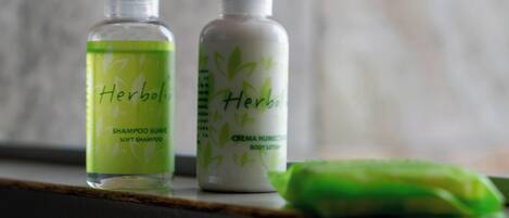Dos botellas de champú y loción corporal 'Herbol' sobre una estantería.