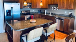 Una cocina moderna con armarios de madera, electrodomésticos de acero inoxidable y encimera de granito.