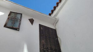 A white building with a brown door and a small window with decorative ironwork. - 113 Livingtarifa Amapola (Tarifa)