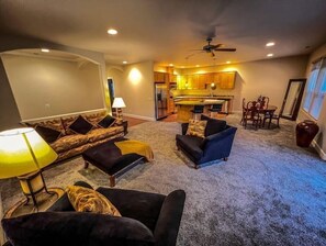 Relax in a spacious living area with a sofa set, armchair, and kitchen area.