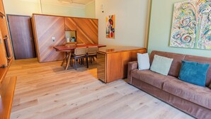Una sala moderna con un sofá, una mesa de comedor y una zona de cocina.