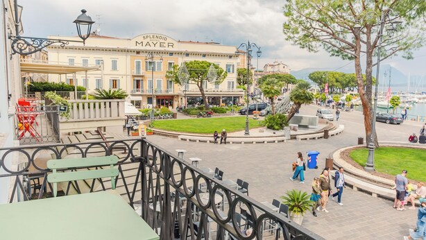 Un hotel con patio central, mobiliario exterior y vistas al puerto deportivo.