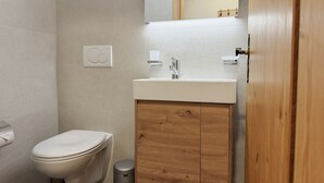 A bathroom with a toilet, sink, and mirror. - Pracondu 2 203 - OUTDOOR & FUN apartment 5 pers (Haute-Nendaz)