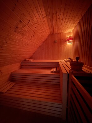 Una sauna con bancos de madera y techo inclinado.
