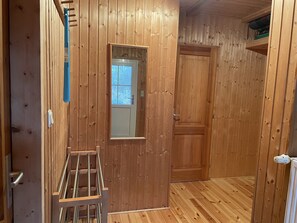 A wooden-paneled room with a door, a window, and a radiator. - Ferienhaus bis 8 Personen mit Sauna, Kinderfreundlich (Pruchten)