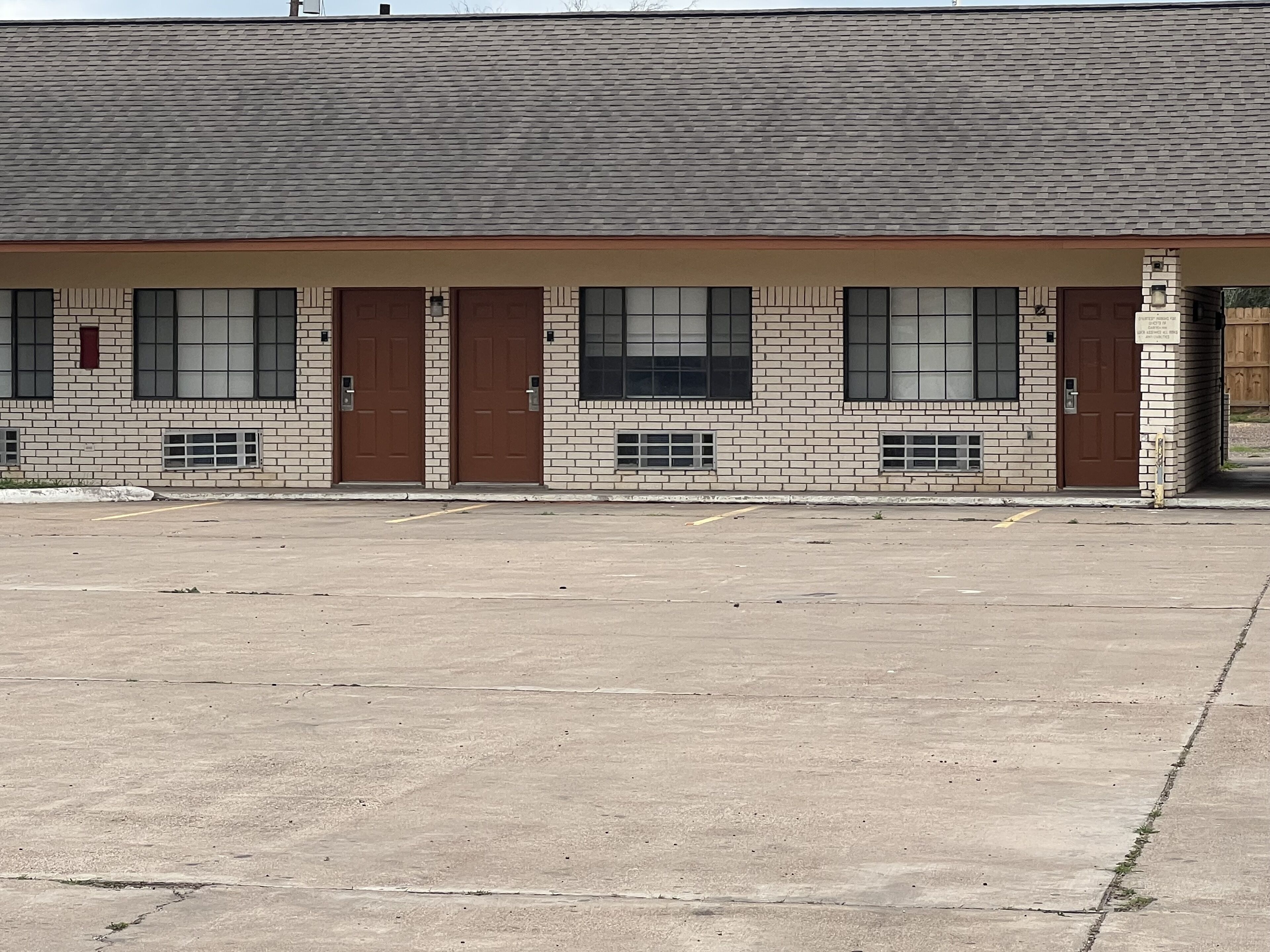 A building with a brick facade, large windows, and a flat roof.