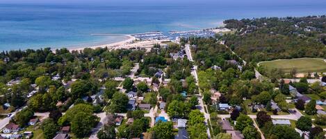 Vista aérea de una zona residencial costera con casas, una playa y un puerto deportivo.