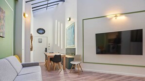 A modern interior with a dining area, a sofa, and a large framed picture on the wall. - Meslay 1 - Three Bedroom Apartment, Sleeps 8 (Paris)