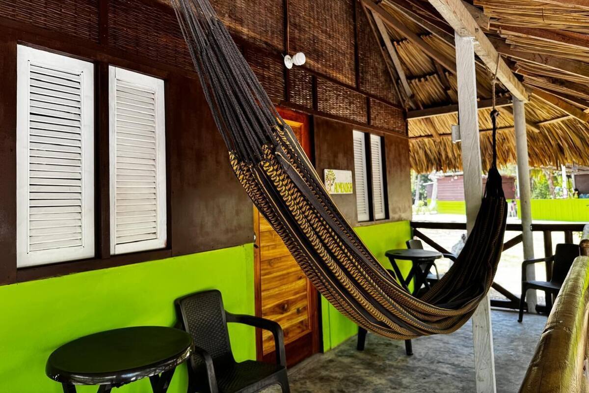A room with a hammock, a table, and chairs.