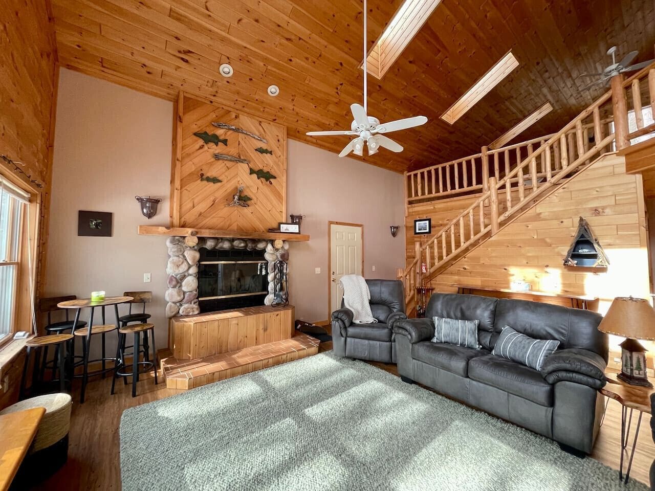 Sink into plush leather seating by your stone fireplace, where rustic wood beams and soaring ceilings create the perfect mountain retreat atmosphere.