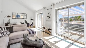 En moderne stue med sofa, sofabord og billeder på væggene.