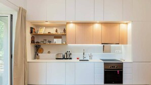 Een moderne keuken met witte kasten, een zwarte oven en een roestvrijstalen spoelbak.