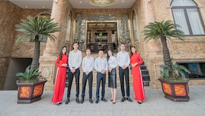 A luxury hotel with a grand entrance, a sign reading "LUXURY HOTEL", and a group of people standing in front. - Luxury Hotel (Van Giang)