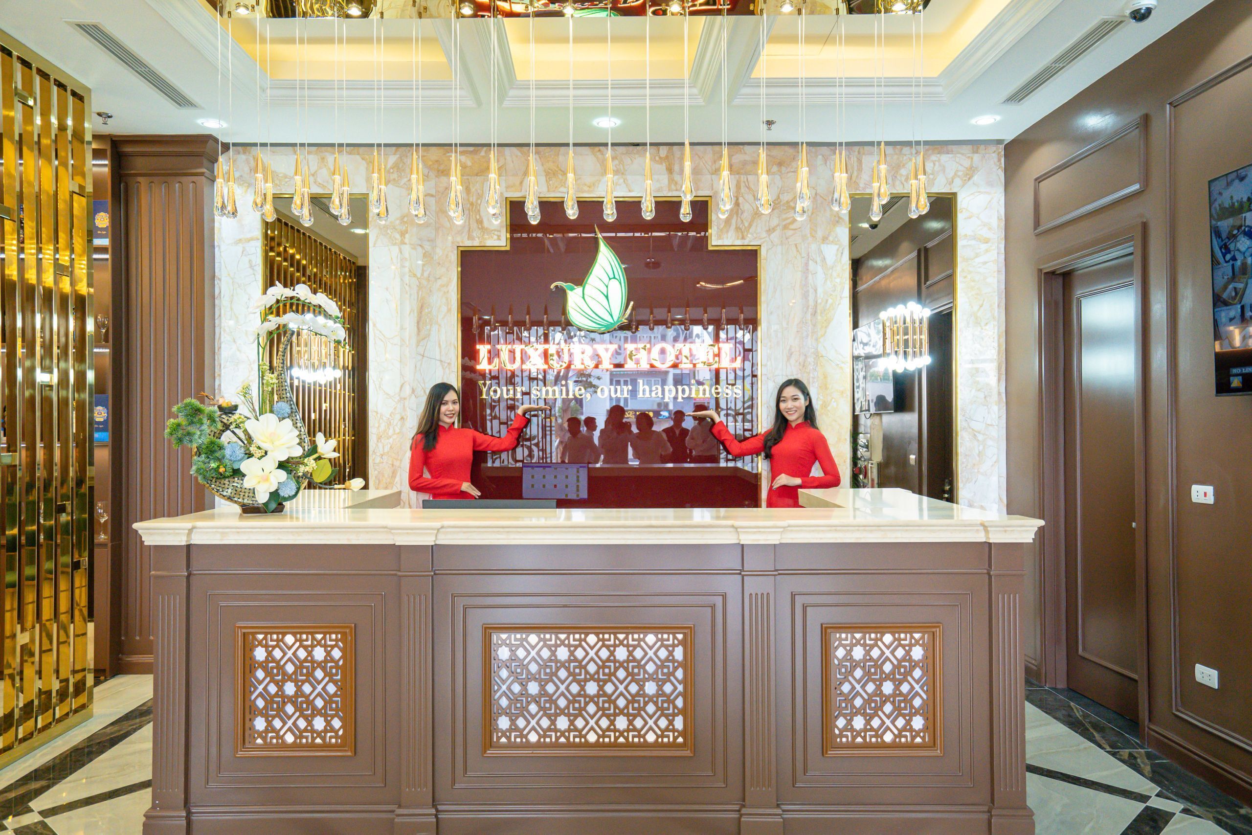 Eine Rezeption mit einer Marmor-Apotheke, einer Zierpflanze und einem Schild mit der Aufschrift 'LUXURY HOTEL'.