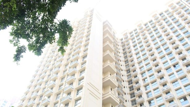 Un immeuble de grande hauteur doté de nombreux balcons et d’un élément vertical central.