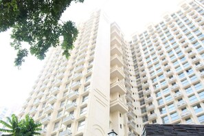 Un edificio de gran altura con múltiples balcones y un elemento vertical central.