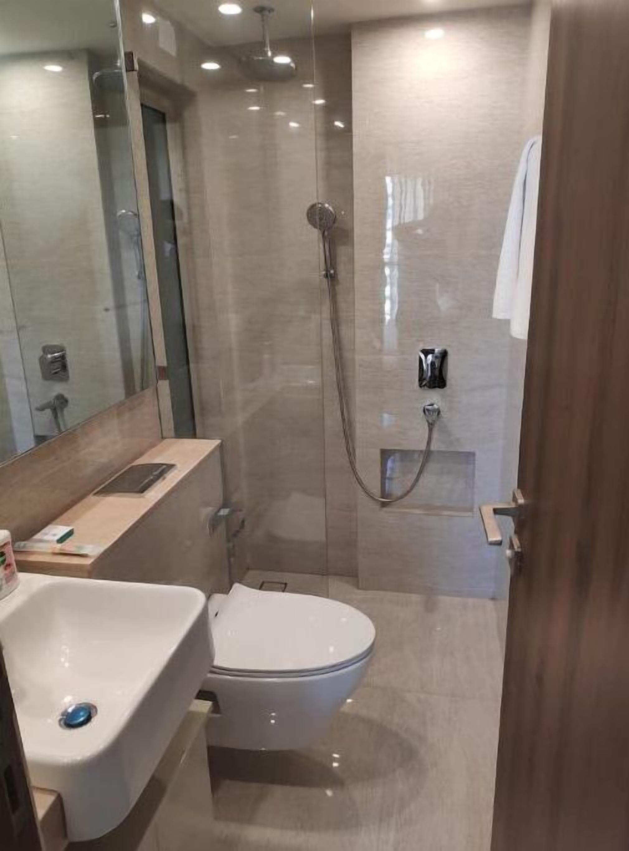 Een moderne badkamer met toilet, wastafel en douche.