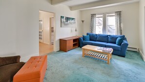 A living room with a blue sofa, a wooden coffee table, and a brown armchair.