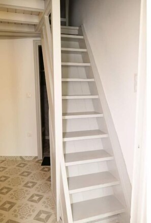 Stairs lead to an upper level with a door at the bottom.