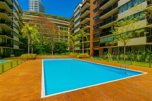 Een seizoensgebonden buitenzwembad en ligstoelen