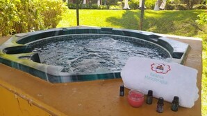 Een hottub met een handdoek waarop 'Balance Masoterapia' staat en essentiële oliën op een tafel.