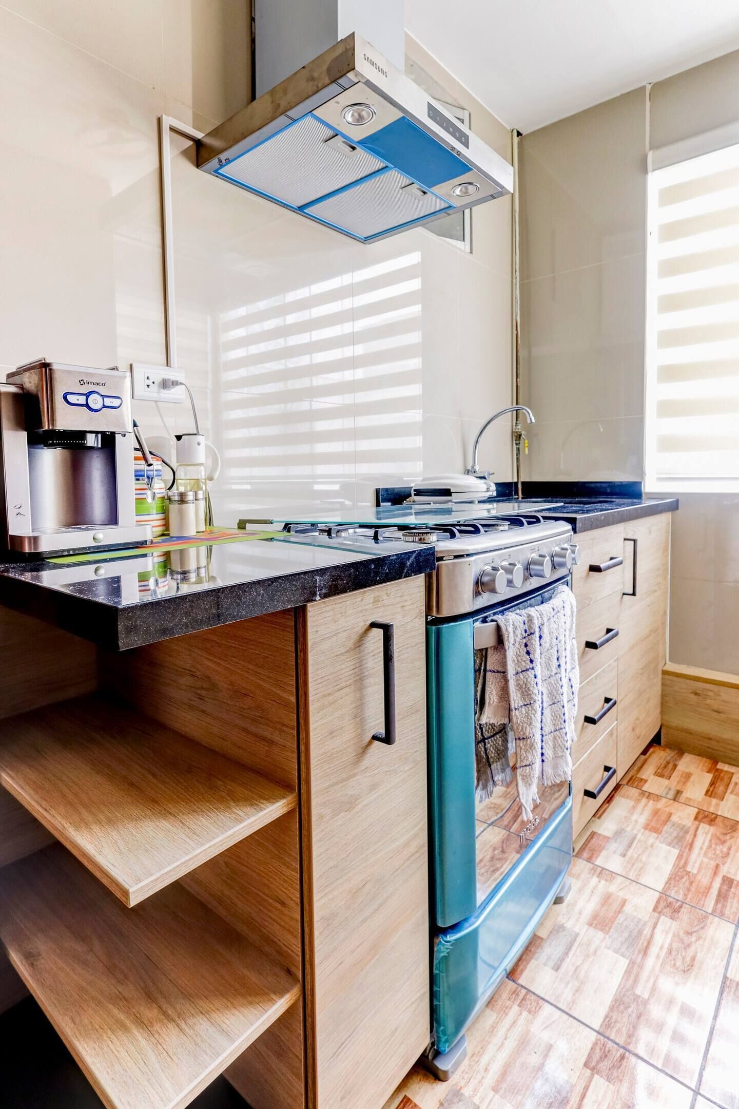 Una cocina moderna con estufa integrada, cafetera y armarios de madera.