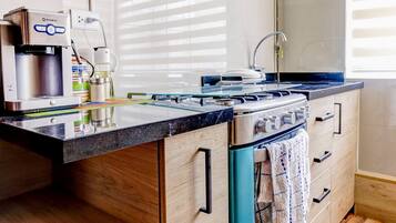 Una cocina moderna con estufa integrada, cafetera y armarios de madera.